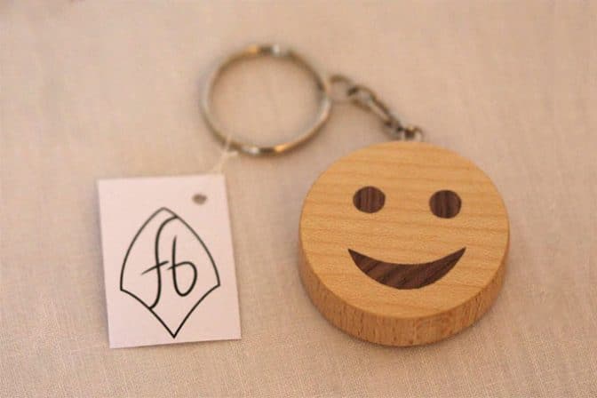 runder Schlüsselanhänger aus hellem Holz mit Smiley